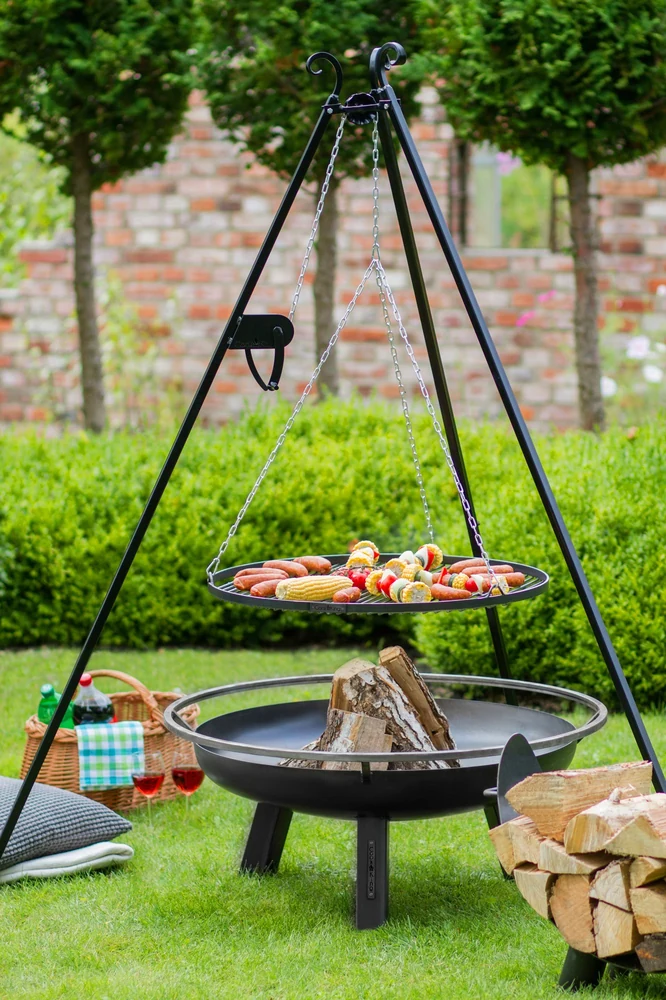 COOK KING tripod grill over a fire bowl on a lawn